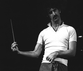 Frank Zappa durante un concerto: "Tutta la carriera di Zappa è costruita sulla qualità della musica, sul lavoro che richiede all'ascoltatore e all'esecutore e prima di tutto all'autore. Per quanto solo una piccola parte della sua produzione sia classificabile come musica da concerto (sinfonica o da camera), Zappa non ha mai perso l'occasione di mettere in primo piano il proprio ruolo di compositore, nel quale le modalità tradizionali, la scrittura minuziosa delle parti, spesso di difficoltà vertiginosa, si abbinano a quelle tipiche del produttore in studio di registrazione o dell'utilizzatore di sistemi computerizzati."