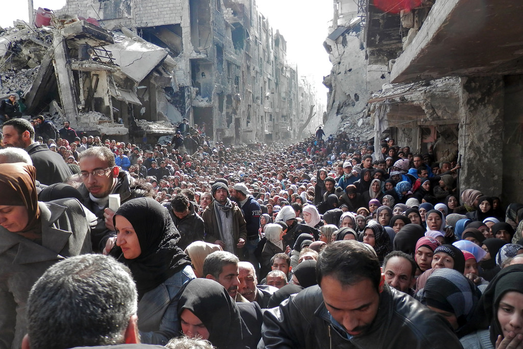 Gennaio 2015, rifugiati siriani in attesa di ricevere razioni di cibo nel campo profughi di Yarmouk, Siria